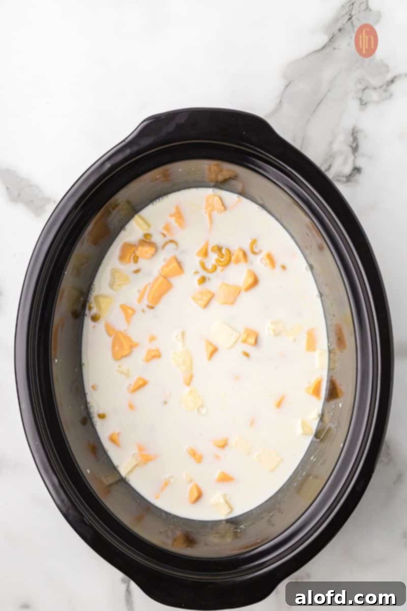 Crockpot with macaroni mixture, showing the cooked pasta and melted cheese.