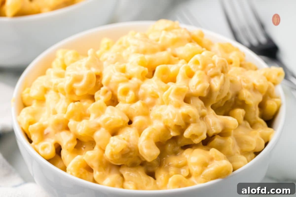 A horizontal shot of a full crockpot of Velveeta mac and cheese, ready for serving.