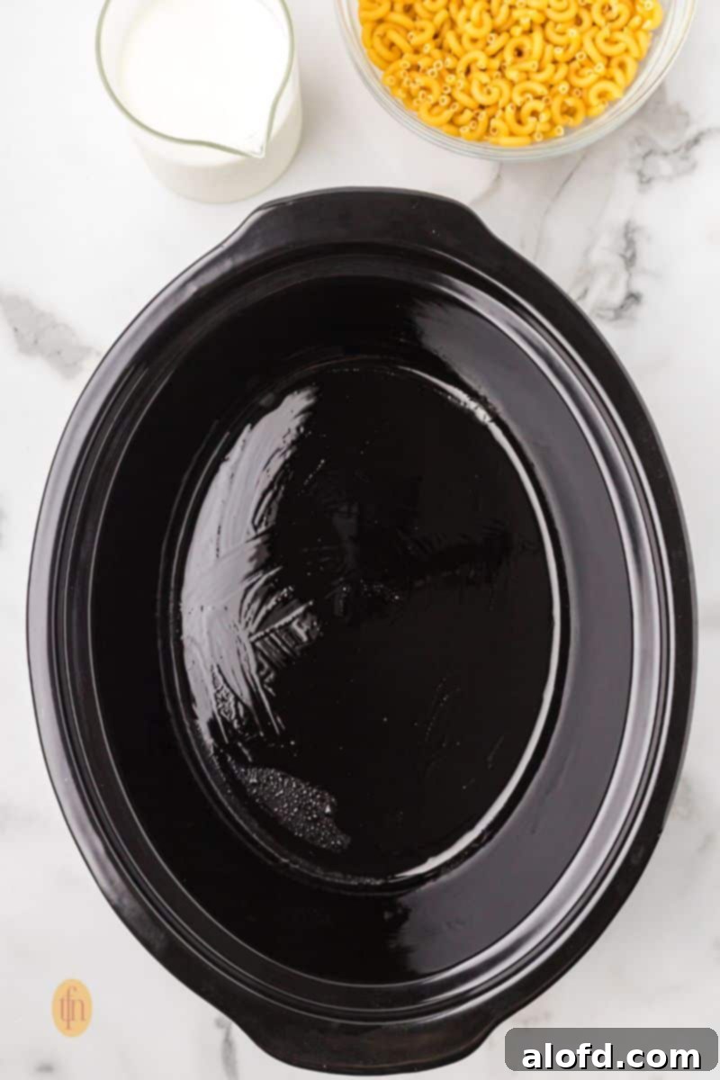 Crock pot with oil and a bowl of macaroni and glass of milk, illustrating the first ingredients.