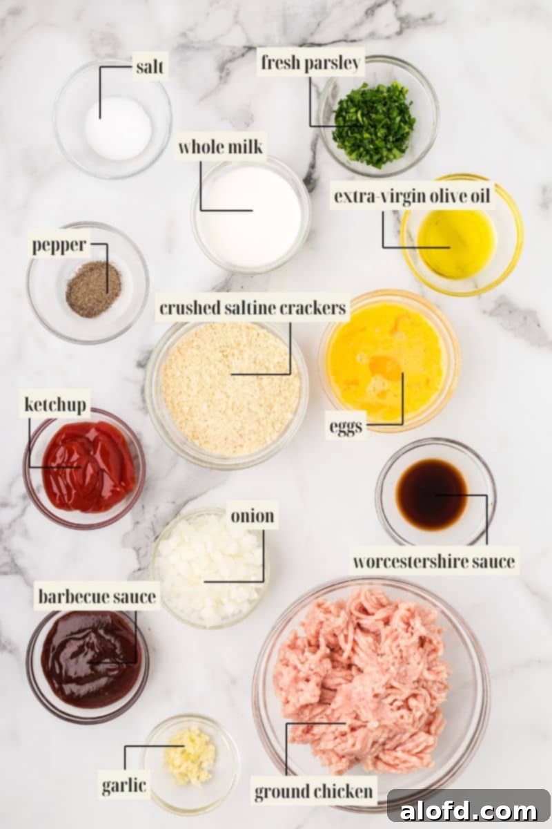 Savory Chicken Meatloaf 5 A flat lay of the labeled ingredients for ground chicken meatloaf: salt, pepper, ketchup, barbecue sauce, garlic, whole milk, crushed saltine crackers, diced onion, ground chicken, fresh parsley, extra virgin olive oil, eggs, and Worcestershire sauce.