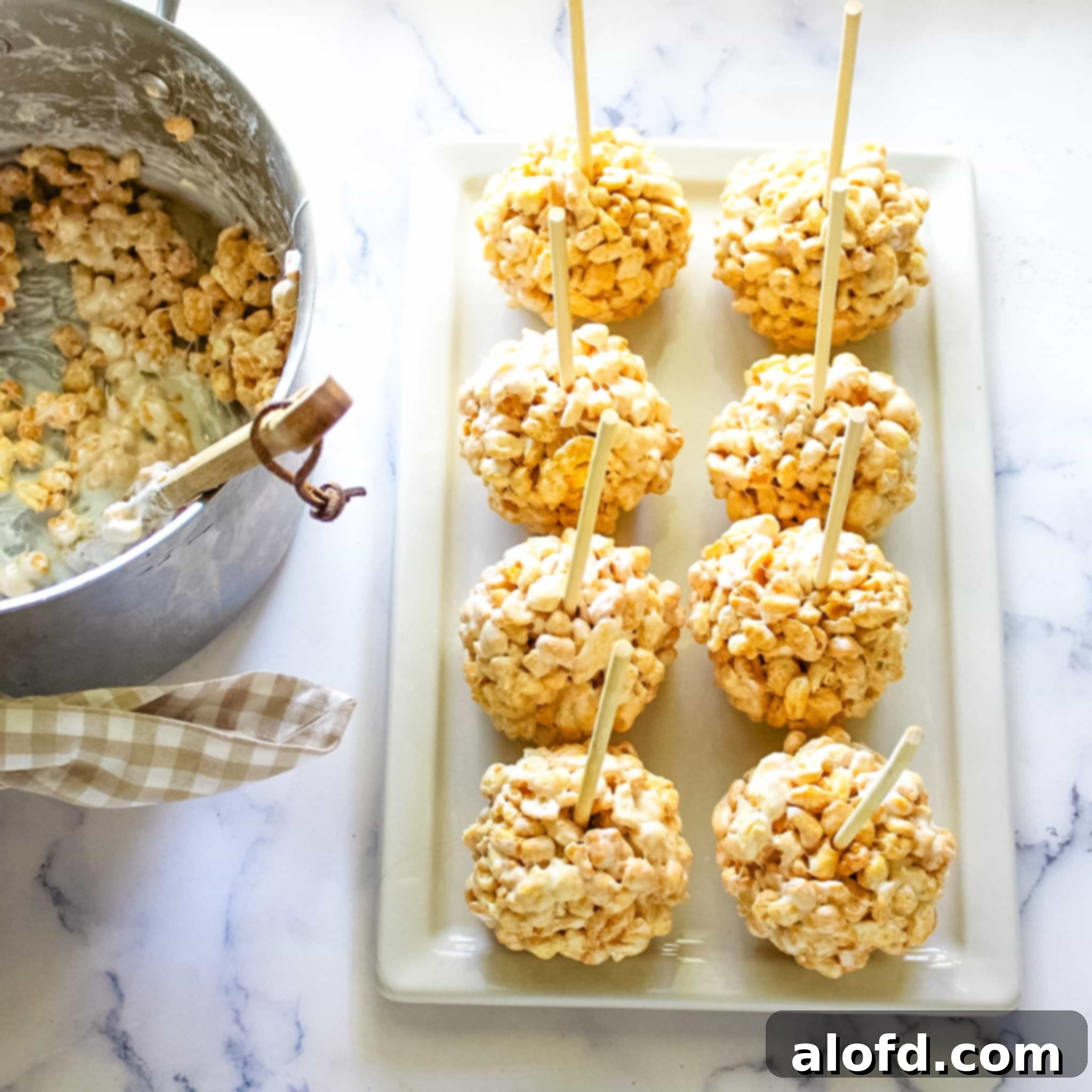 A close-up of beautifully shaped cereal ball marshmallow snacks, featuring different cereals like Corn Pops, Rice Krispies, and Fruity Pebbles, each adorned with a wooden stick.