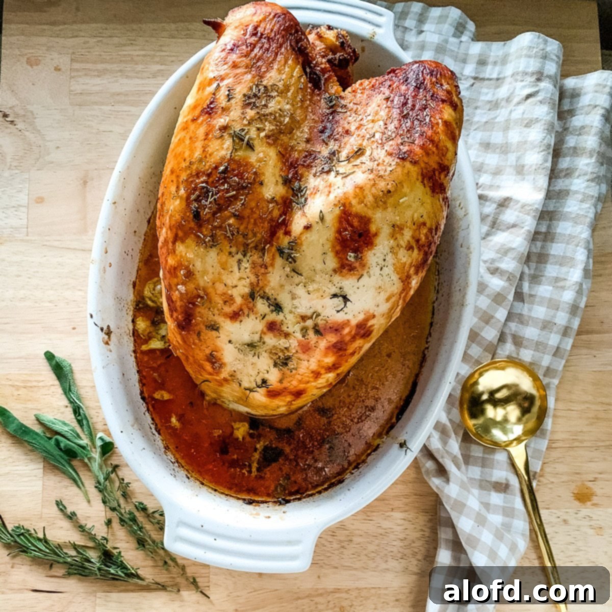 Tender Buttermilk Turkey Breast 2 A perfectly roasted buttermilk brined turkey breast, golden brown and glistening with juices, resting in a roasting pan.