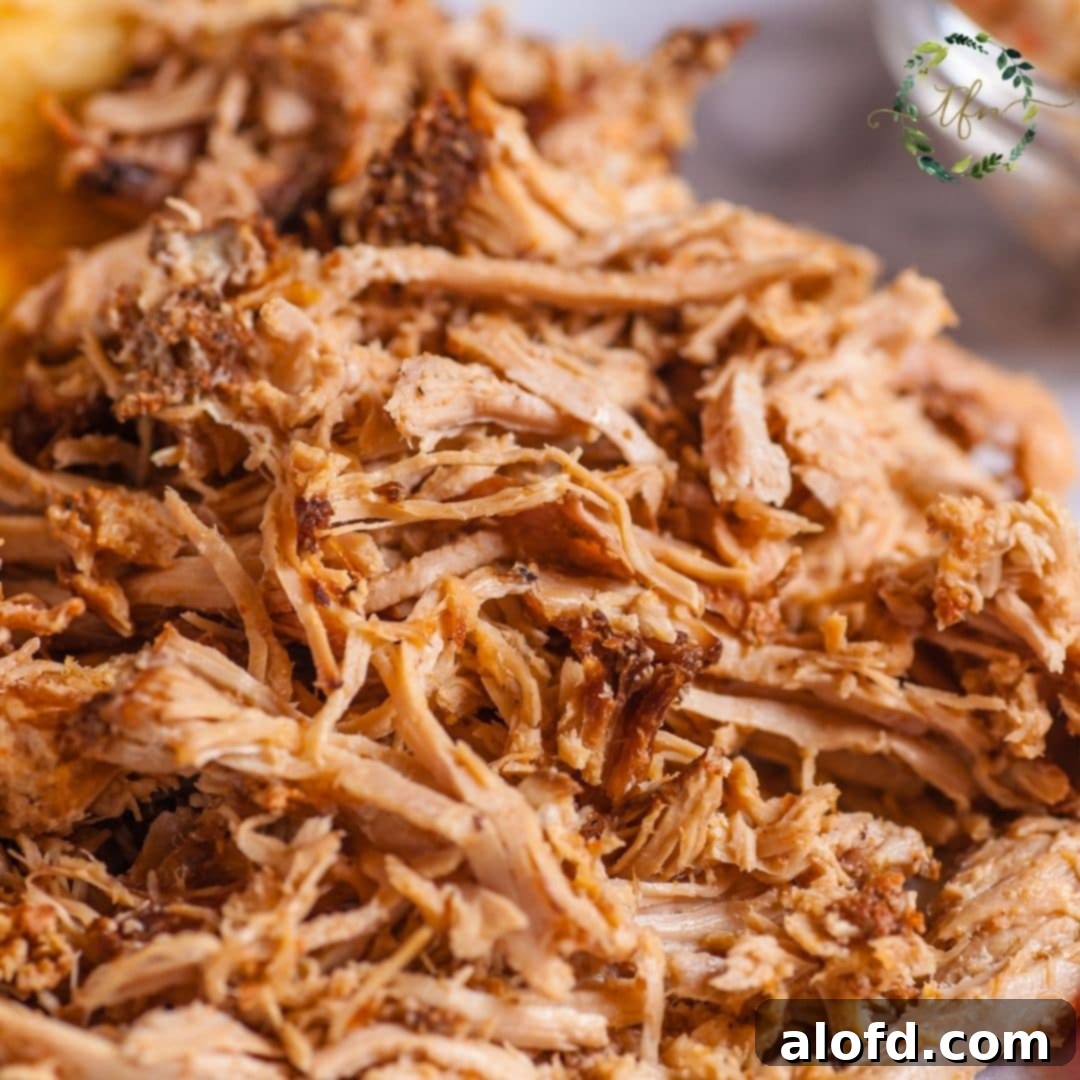 Fall-Apart Slow Cooker Pot Roast 5 A bowl of tender, shredded roast beef, garnished with fresh herbs, ready to be served.