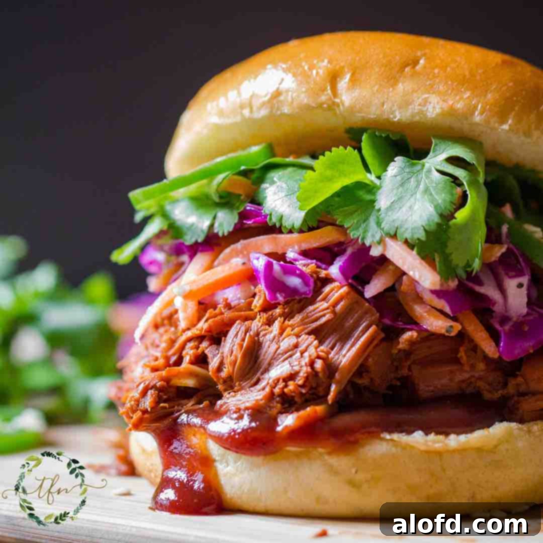 Fall-Apart Slow Cooker Pot Roast 6 A delicious BBQ Pulled Beef sandwich on a toasted roll, ready to be enjoyed.