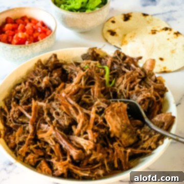 Fall-Apart Slow Cooker Pot Roast 8 A white bowl filled with savory shredded chuck roast.