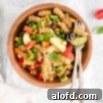 Zesty Italian Pasta Salad and silverwares on a wood bowl.