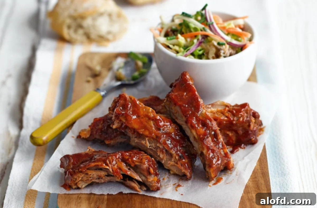 A plate of perfectly cut ribs served alongside a fresh bowl of creamy coleslaw, ideal for a summer BBQ.