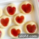 Top 10 Holiday Cookie Delights 13 Cute heart jam cookies on a white platter.