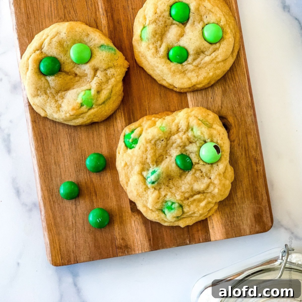 Top 10 Holiday Cookie Delights 15 Green m and m cookies on a wooden serving board, perfect for a cookie exchange.