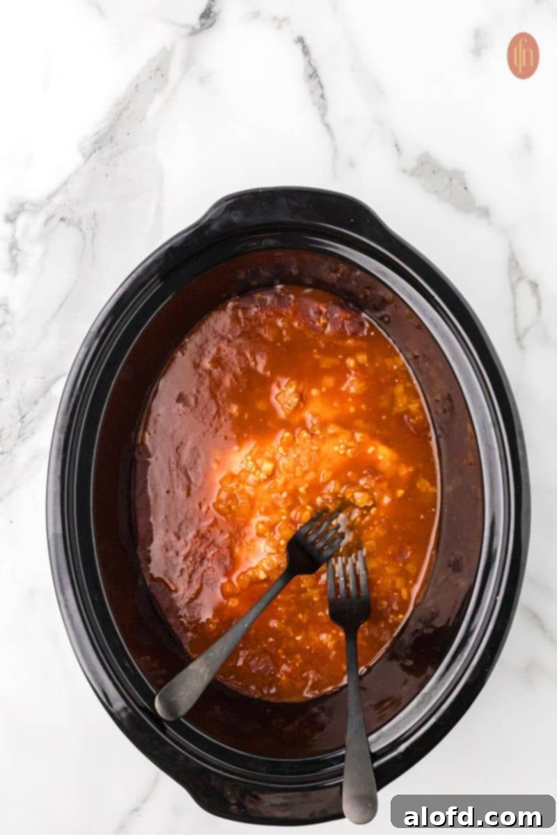 Remaining enchilada sauce being poured over the chicken.