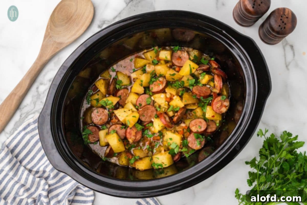 Slow-Cooker Sausage and Potato Delight 14 Horizontal image of slow cooker sausage and potatoes in a crock pot.