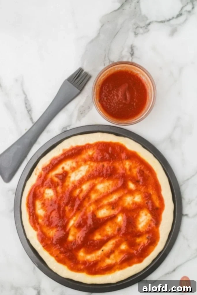 Homemade Pizza with a Crust Made from Scratch 9 Dough topped with marinara sauce.