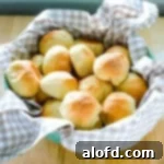 Sourdough rolls on a kitchen towel wrapped bowl.